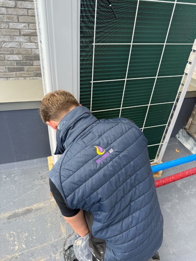 Engineer commissioning an outdoor heat pump unit